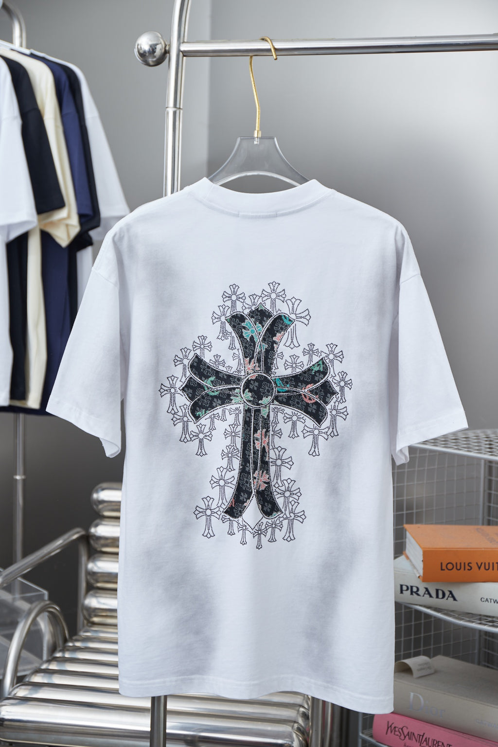 White short-sleeve T-shirt with large back cross graphic in black, green, and teal