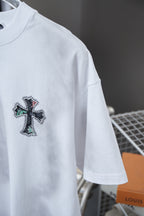 White short-sleeve T-shirt with small cross graphic on the sleeve