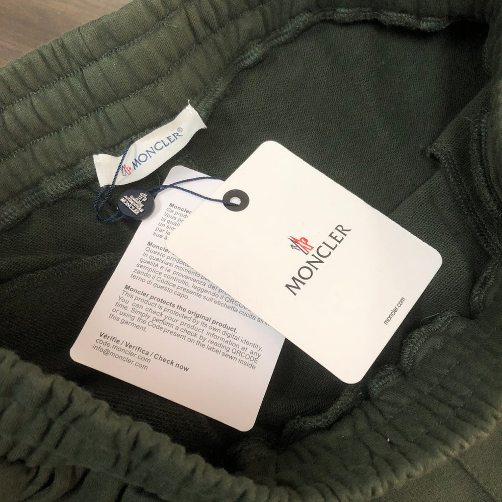 Stone Island dark green shorts with elastic waistband and hanging brand tags