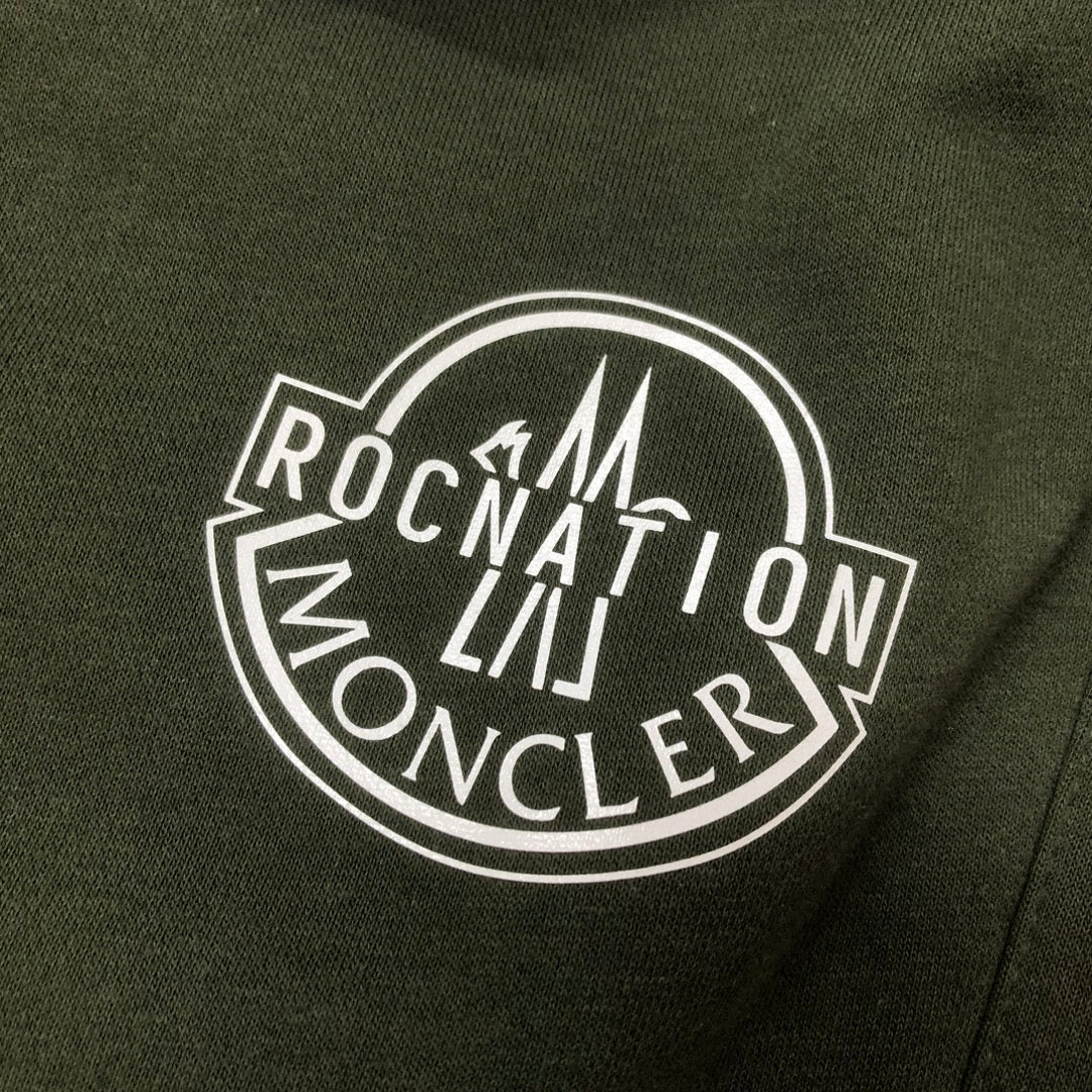 Stone Island dark green shorts with large circular Rocket logo graphic