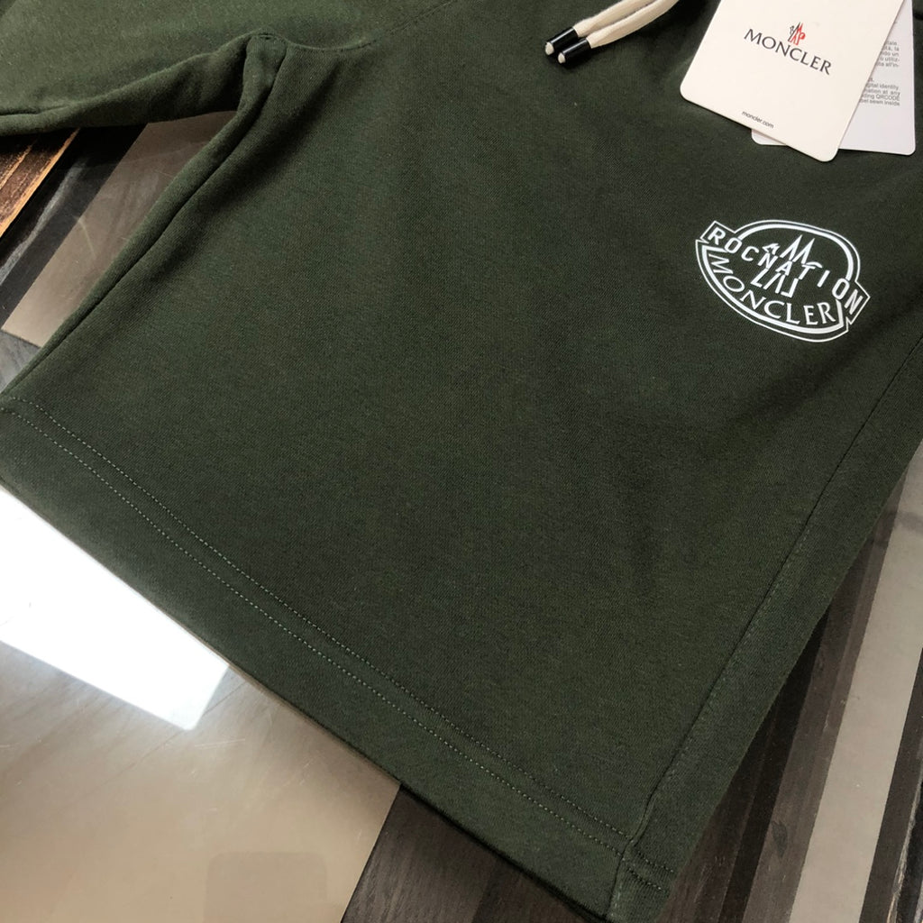 Stone Island dark green shorts with circular logo patch on front hem