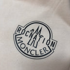 Embroidered round logo patch with MONCLER text on light fabric