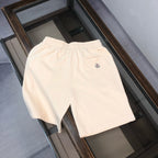 Cream drawstring shorts with small circular logo on the front