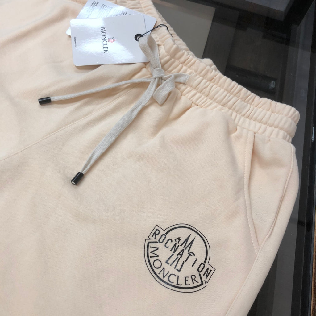 Cream drawstring shorts close-up with ruched waistband and logo