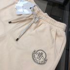 Cream drawstring shorts close-up with ruched waistband and logo