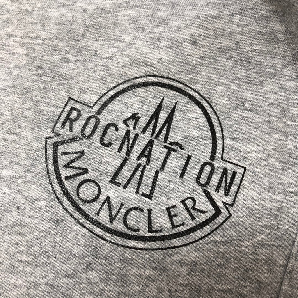 Close-up of circular logo on heather gray shorts