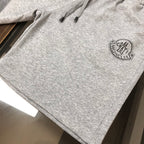 Light gray shorts with drawstring ties and small circular logo patch on side