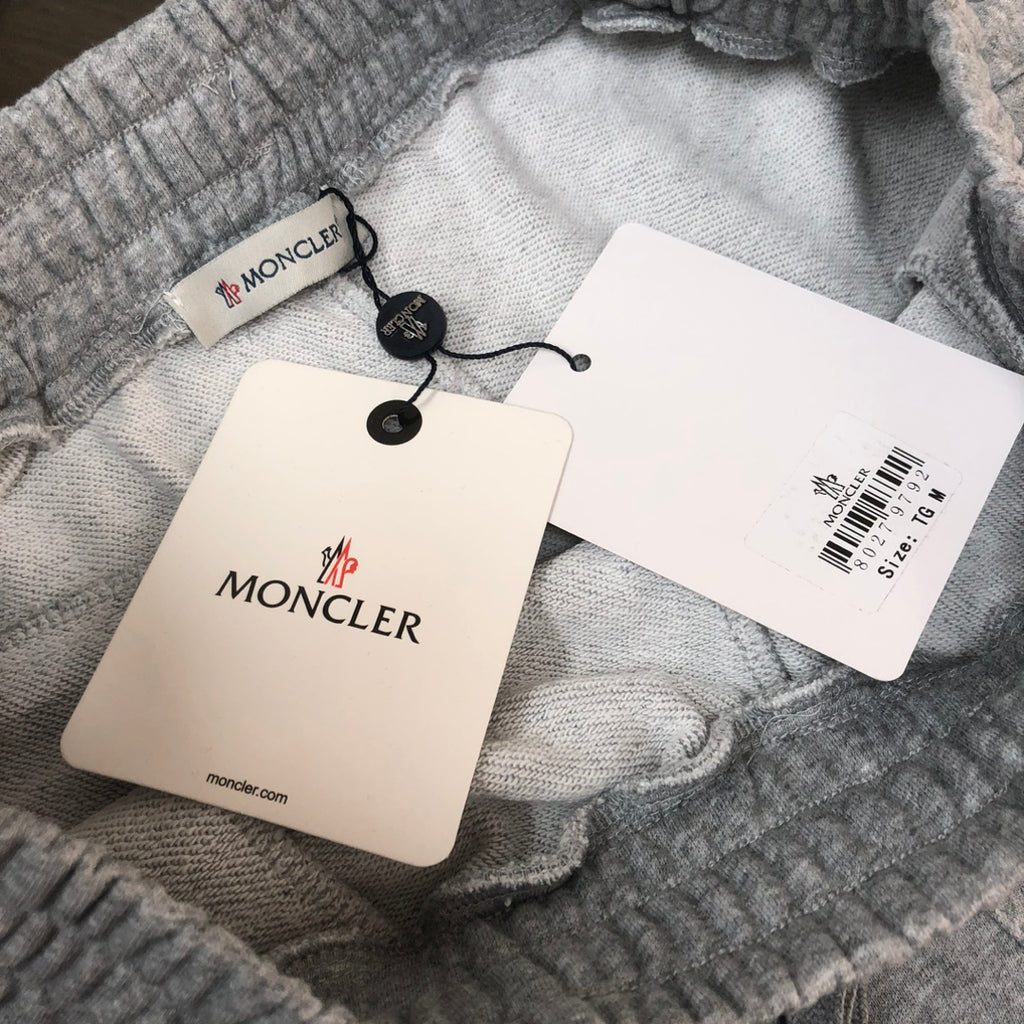 Gray shorts with Moncler hang tags and barcode label attached
