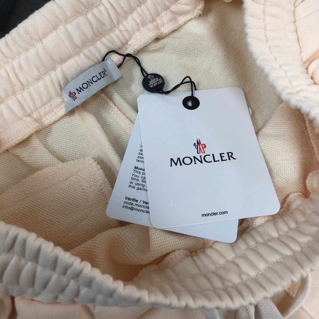 Cream shorts with elastic waistband and hanging tag labeled MONCLER