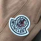 Stone Island logo patch on tan shorts, circular embroidered emblem on fabric