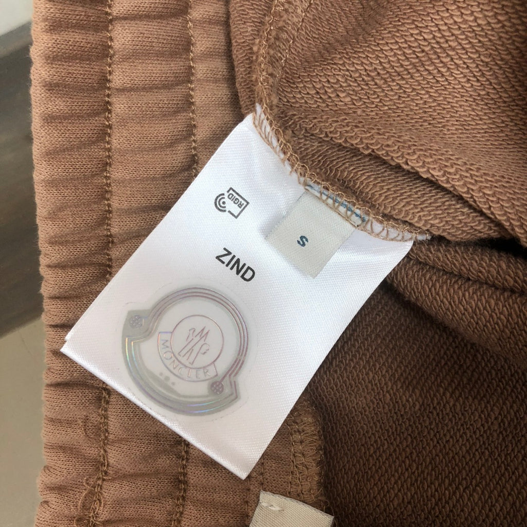Stone Island shorts size label 'S' on tan fabric with care icon