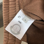 Stone Island shorts size label 'S' on tan fabric with care icon