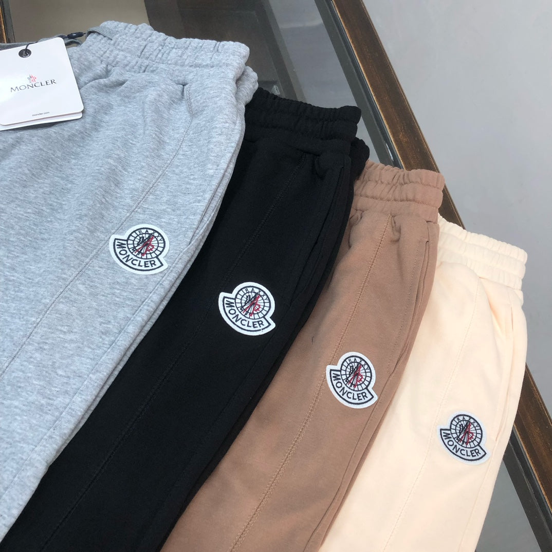 Logo shorts in light gray, black, taupe, and cream, each with circular patch