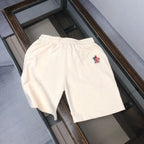 Cream drawstring shorts with small black logo on the back right side