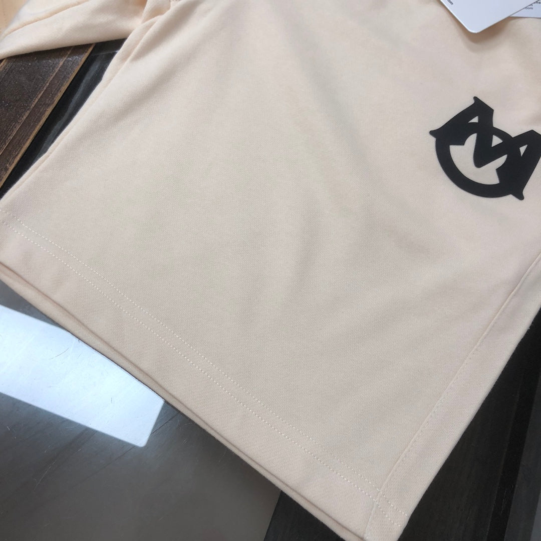 Cream shorts with black logo emblem on the front right leg