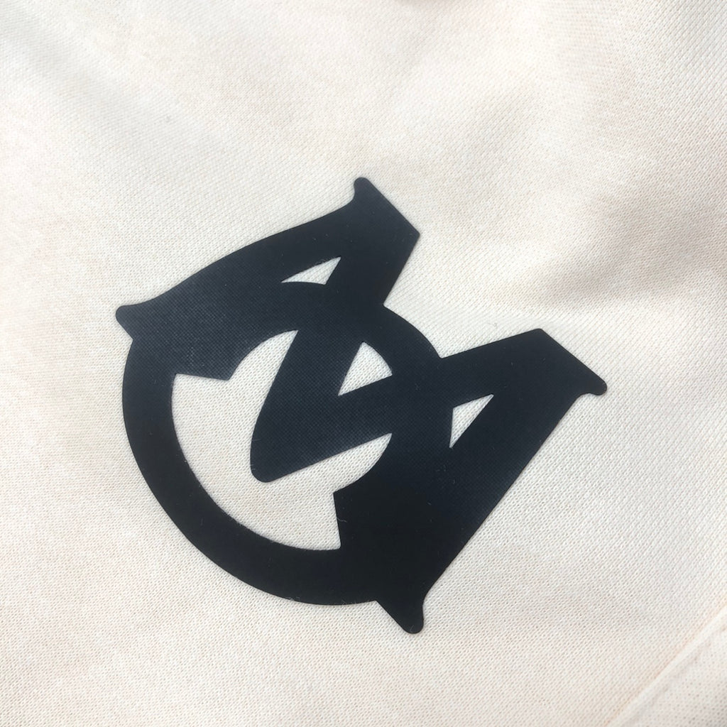 Cream shorts fabric with large black logo graphic on the front