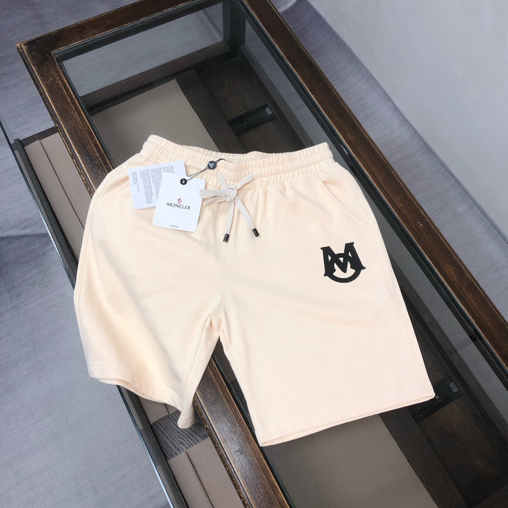 Cream drawstring shorts with elastic waistband and black front logo patch