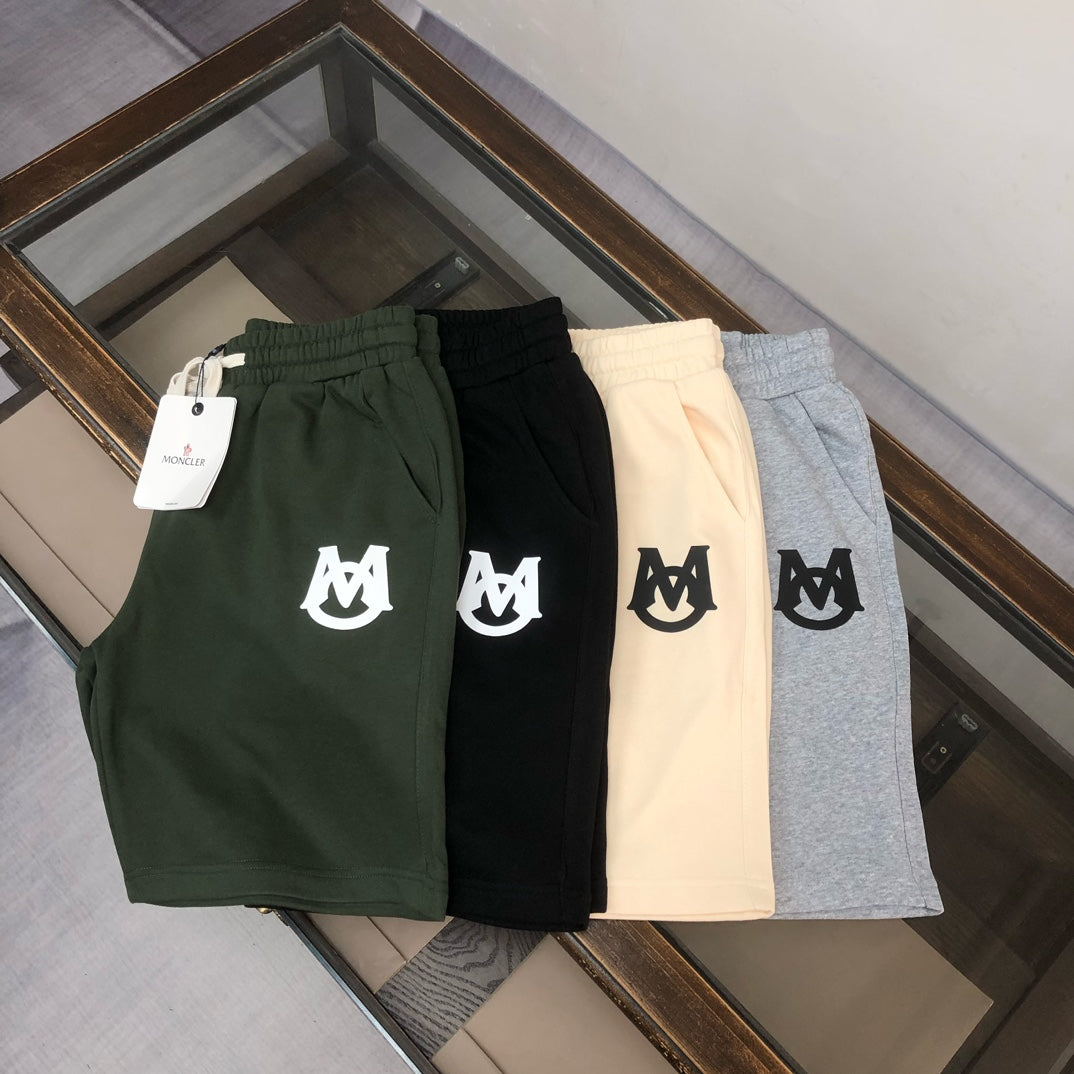 Assorted drawstring shorts in dark green, black, cream, and light gray with white logo