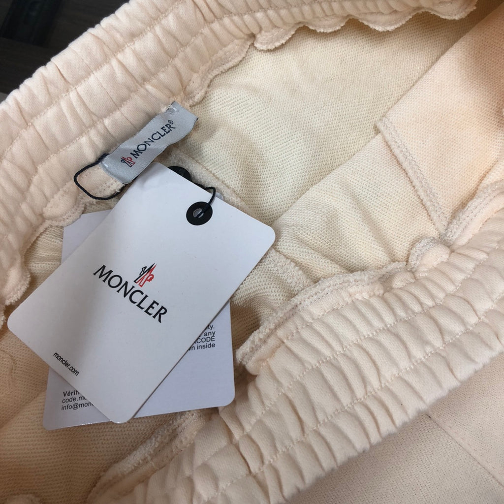 Cream elastic waistband shorts with ruched drawstring and hanging label tags
