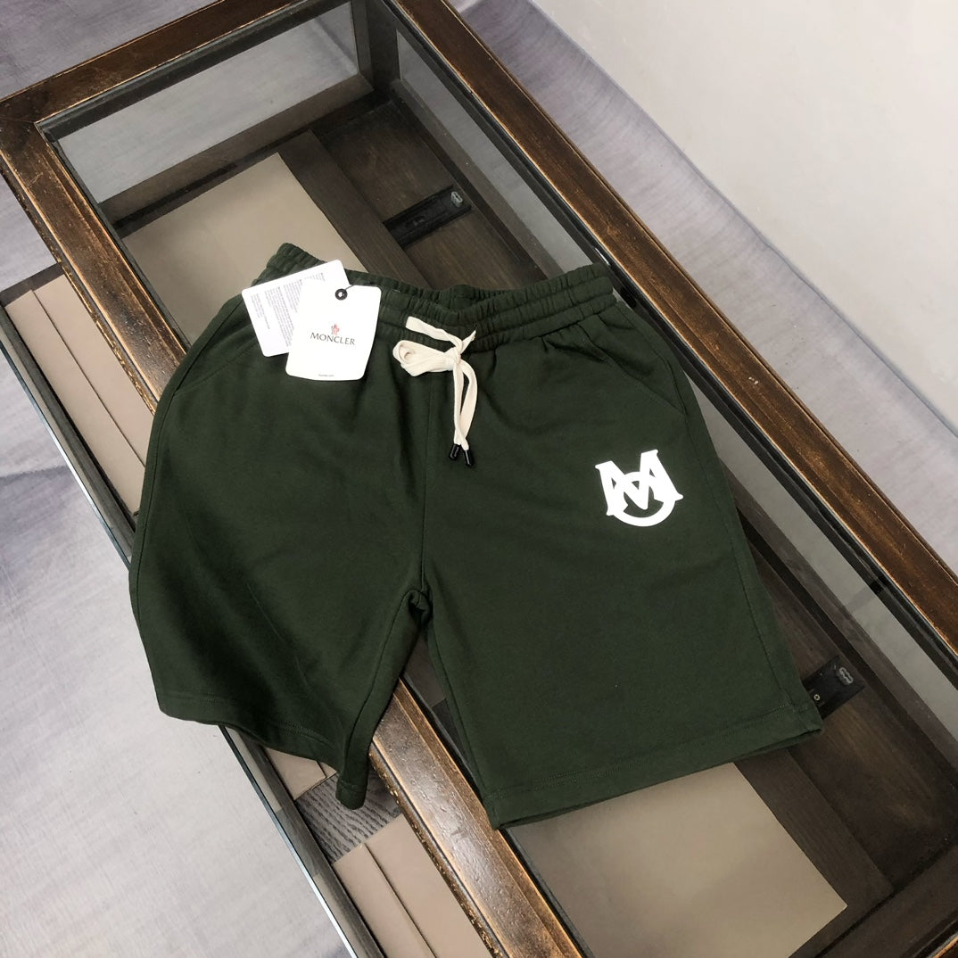 Dark green drawstring shorts with white logo on left thigh