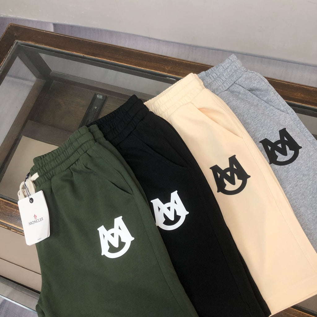 Drawstring shorts in dark green, black, and light beige with white logos