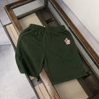 Dark green drawstring shorts with small red-and-white logo on right thigh