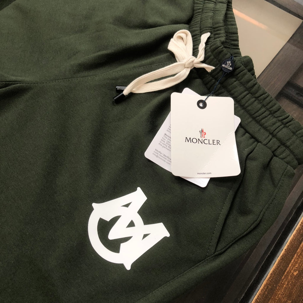Dark green shorts with elastic waistband, white logo print, and drawstring