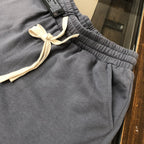 Gray sweat shorts with ribbed elastic waistband and cream drawstring