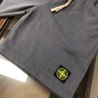 Gray shorts with stitched hemline and black Stone Island logo patch