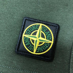 Stone Island embroidered logo patch on green fabric