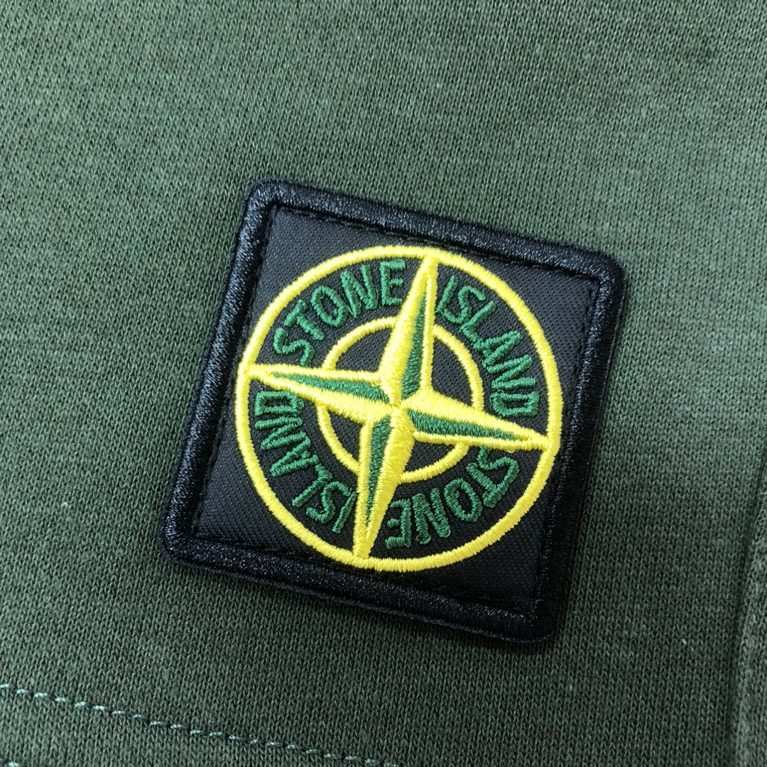Stone Island embroidered logo patch on green fabric