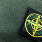 Stone Island logo patch detail on green knit fabric