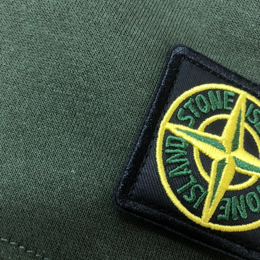 Stone Island logo patch detail on green knit fabric