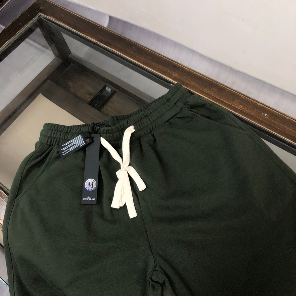 Stone Island dark green shorts with white drawstring, elastic waistband, and tag