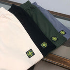 Shorts in dark colors (black, green, gray) with Stone Island logo patches