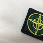 Cream fabric shorts with Stone Island logo patch close-up