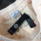 Cream shorts interior with Stone Island size tag and care labels