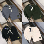 Drawstring shorts in navy, dark green, black, and white with logo patches