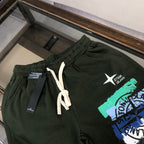 Stone Island green shorts with elastic waist, white drawstring, and front logo graphic
