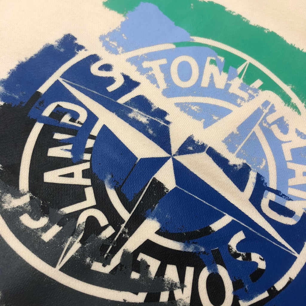 Stone Island logo print close-up on blue and green paint-stroke shorts