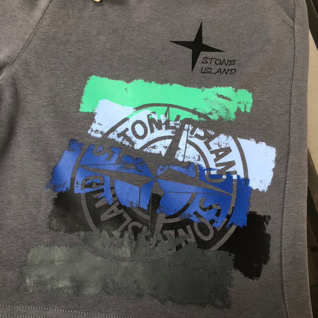 Stone Island grey shorts with green, blue, and white graffiti graphic and star
