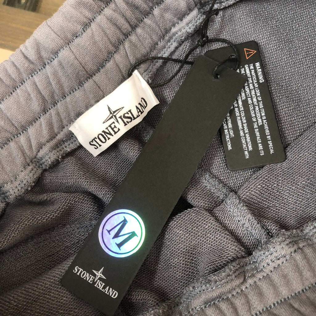 Stone Island grey shorts with elastic waistband, black tag, and white drawstring