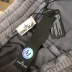 Stone Island grey shorts with elastic waistband, black tag, and white drawstring