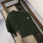 Dark green Stone Island shorts with side logo patch