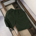Dark green drawstring shorts with elastic waistband