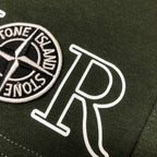 Green shorts detail with Stone Island circular logo patch and 'DIOR' print