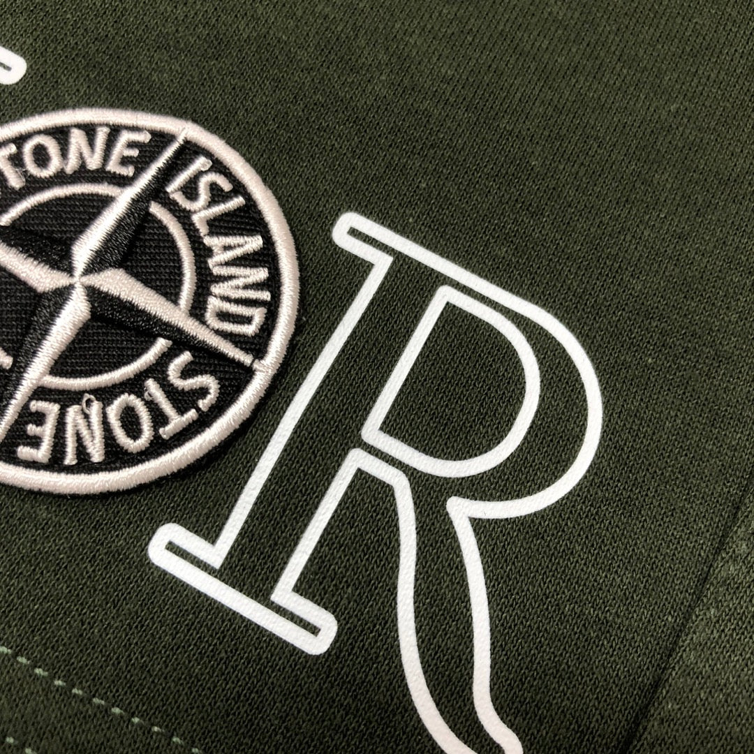 Green shorts detail with Stone Island circular logo patch and 'DIOR' print