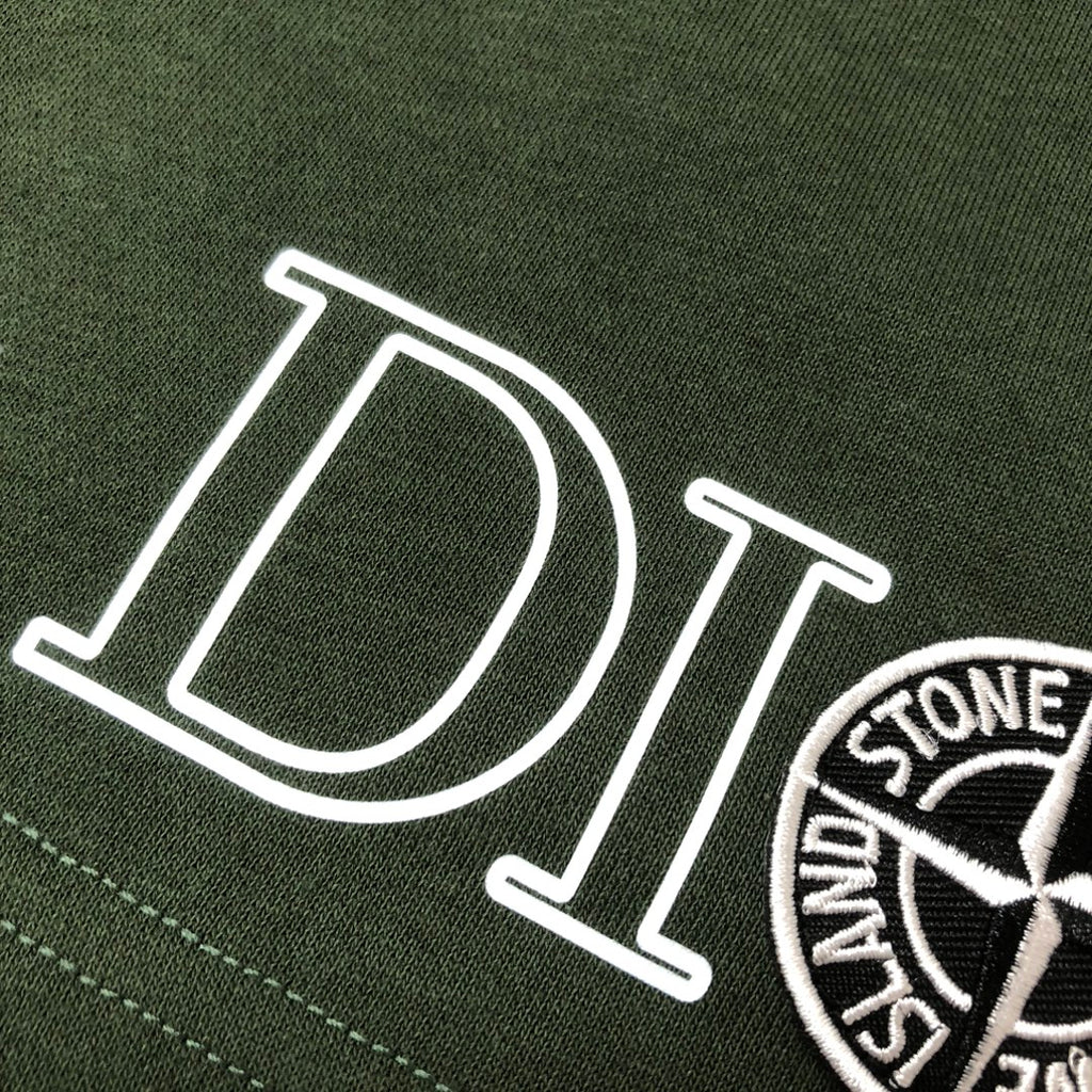 Green fabric shorts with large 'DIOR' lettering and circular logo patch