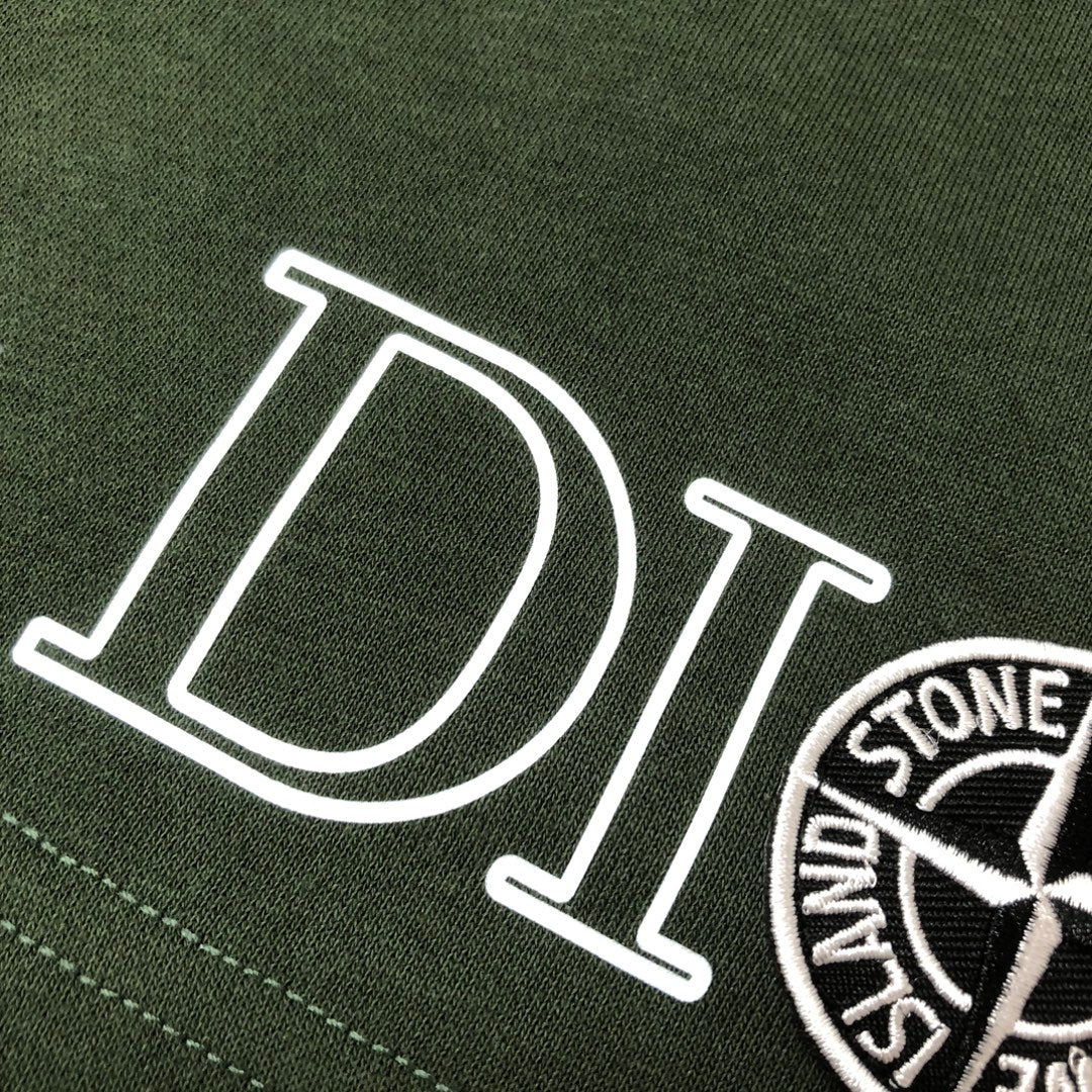 Green fabric shorts with large 'DIOR' lettering and circular logo patch