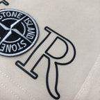 Stone Island off-white shorts close-up of Dior logo and Stone Island emblem